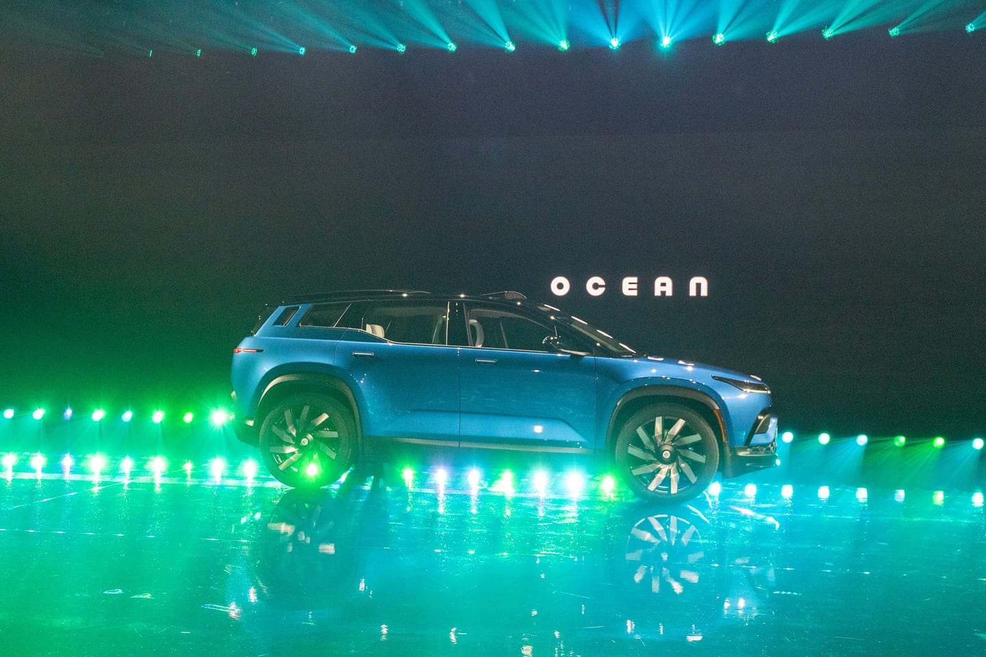 A Fisker Ocean on stage under green light beams with OCEAN on the screen