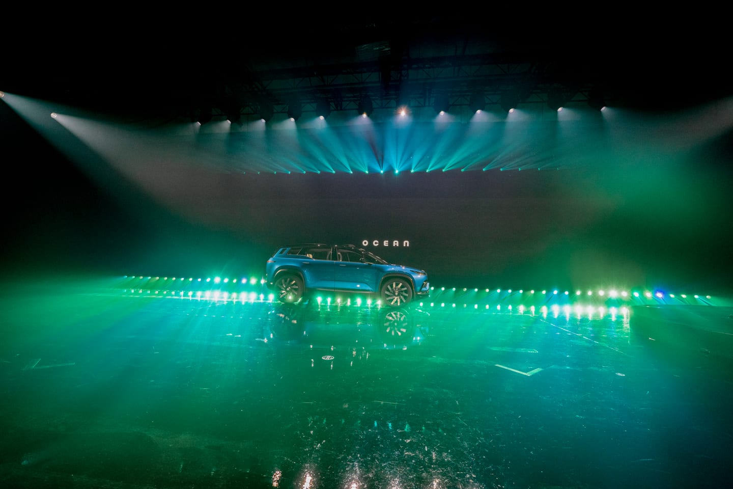 A Fisker Ocean on the green-lit stage seen across the empty floor