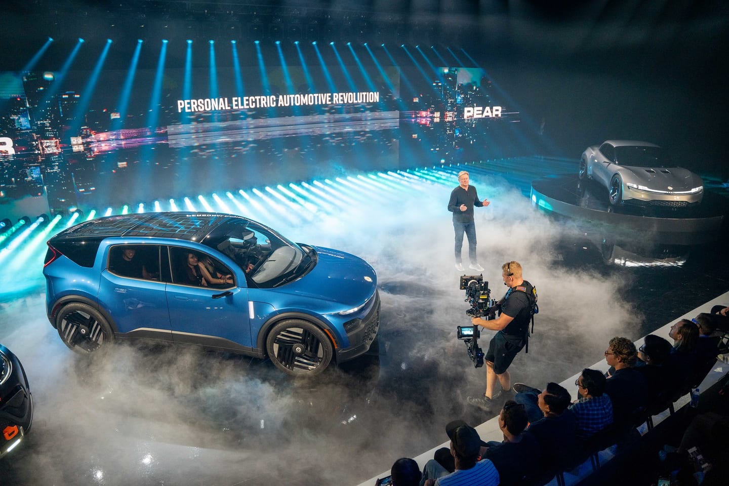 The Fisker PEAR on stage, the screen reading Personal Electric Automotive Revolution