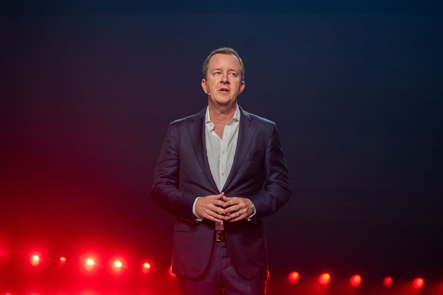A speaker on the darkened stage above a row of red lights