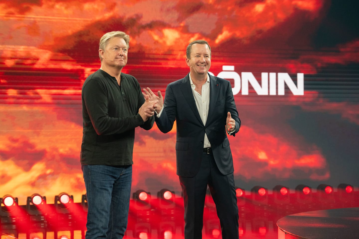 Two executives on stage in front of the RONIN screen