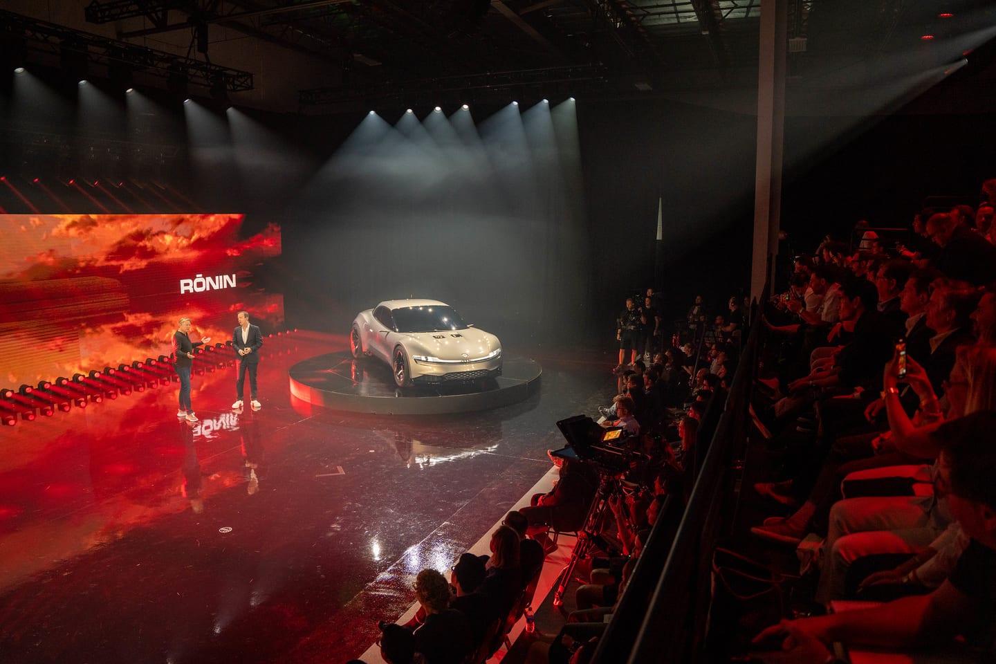 Wide view of the audience facing the Ronin on the lit stage