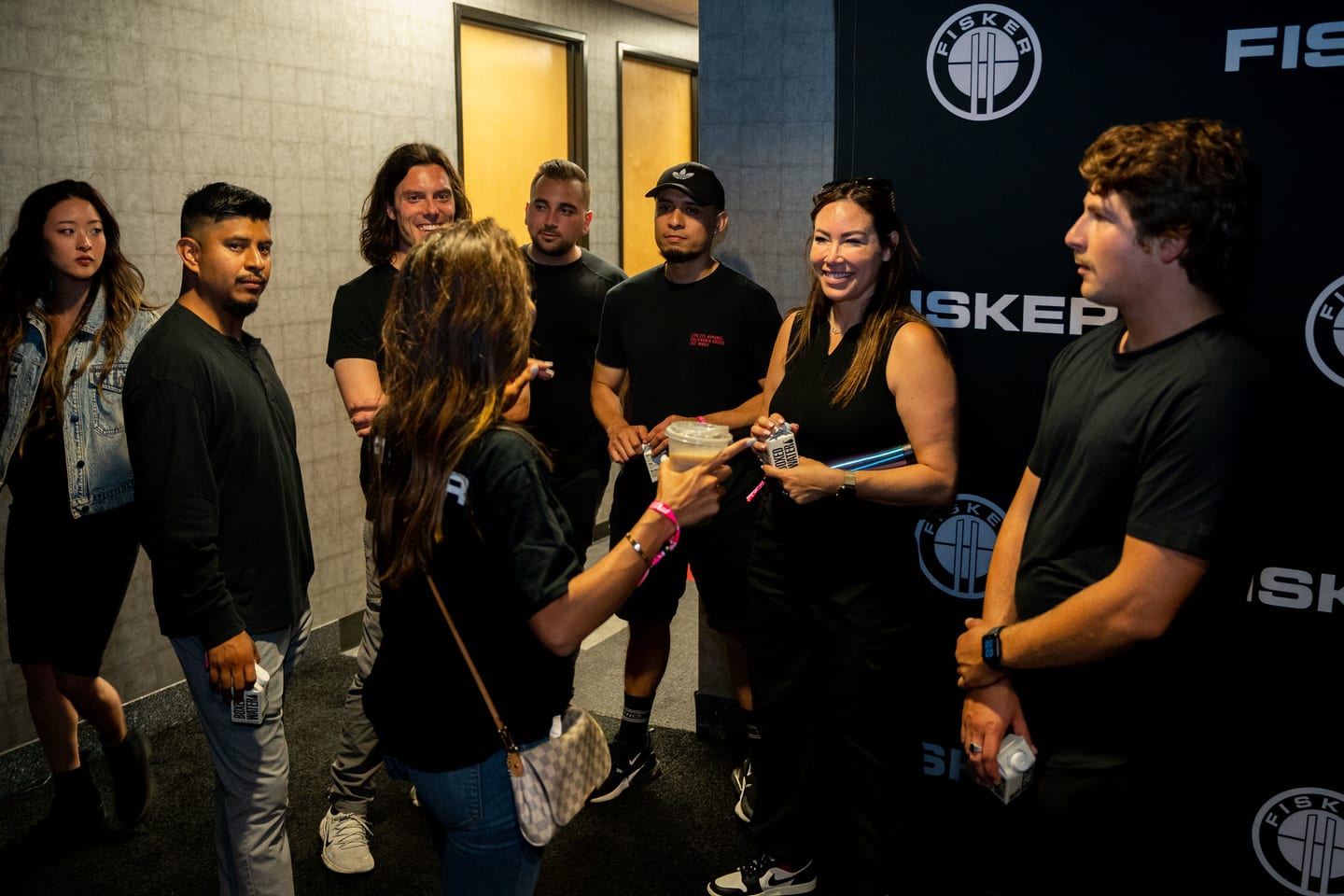 Event staff gathered together beside the FISKER wall