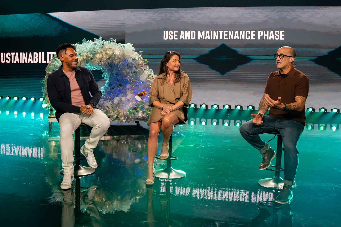 Three speakers seated on stage during the use and maintenance segment