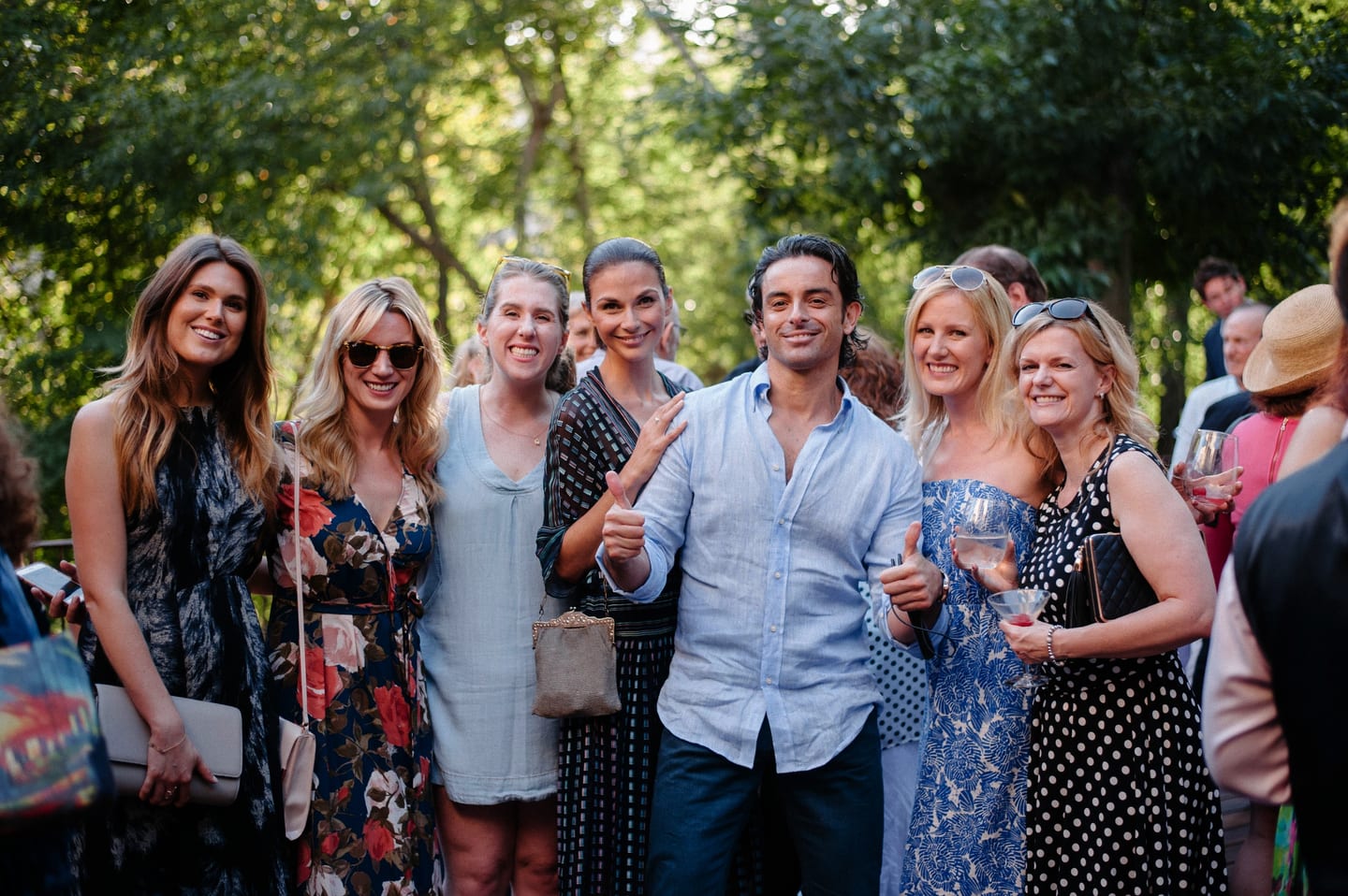 Group of guests posing together at a daytime garden party