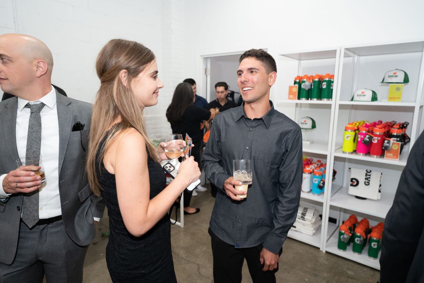 Guests talking at the reception beside a shelf of Gatorade bottles