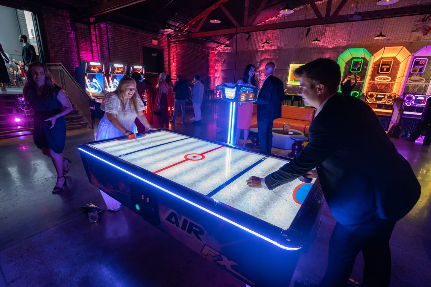 Guests playing air hockey on a lit table at the Athlete of the Year party