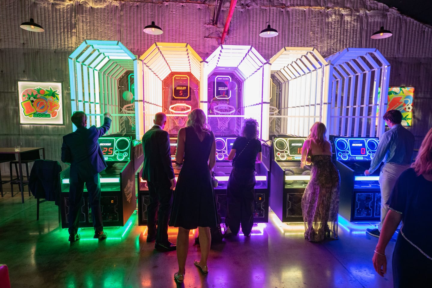 Lit arcade booths lining the venue wall