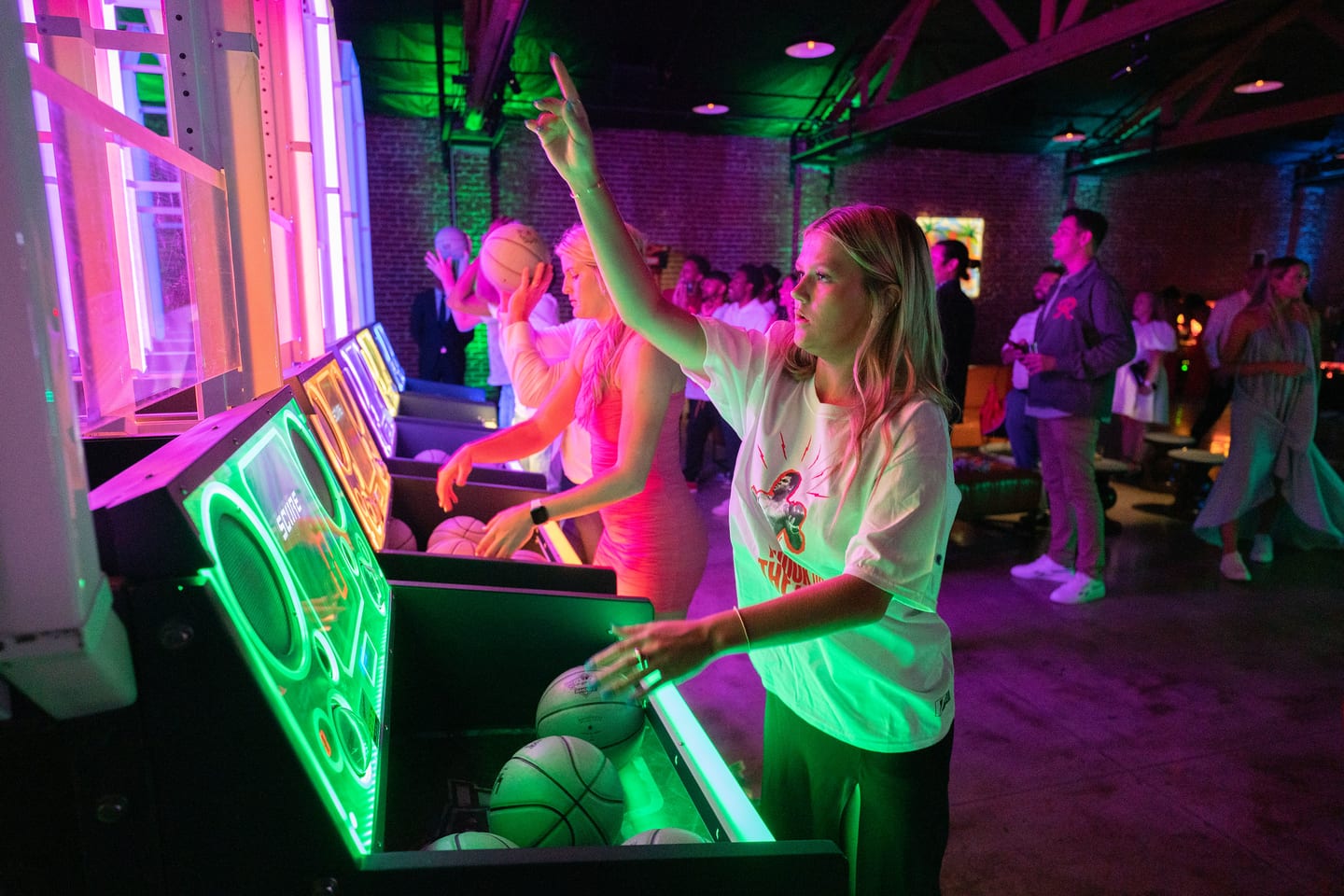 A guest playing an arcade cabinet in neon light