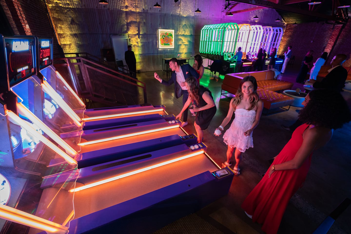 The arcade floor in neon light with guests playing