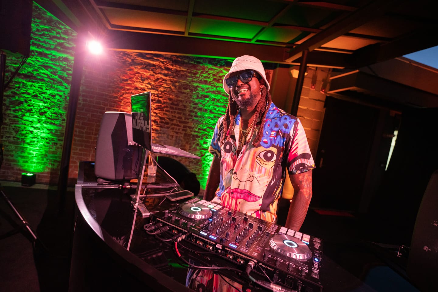 The DJ under green light at the after-party