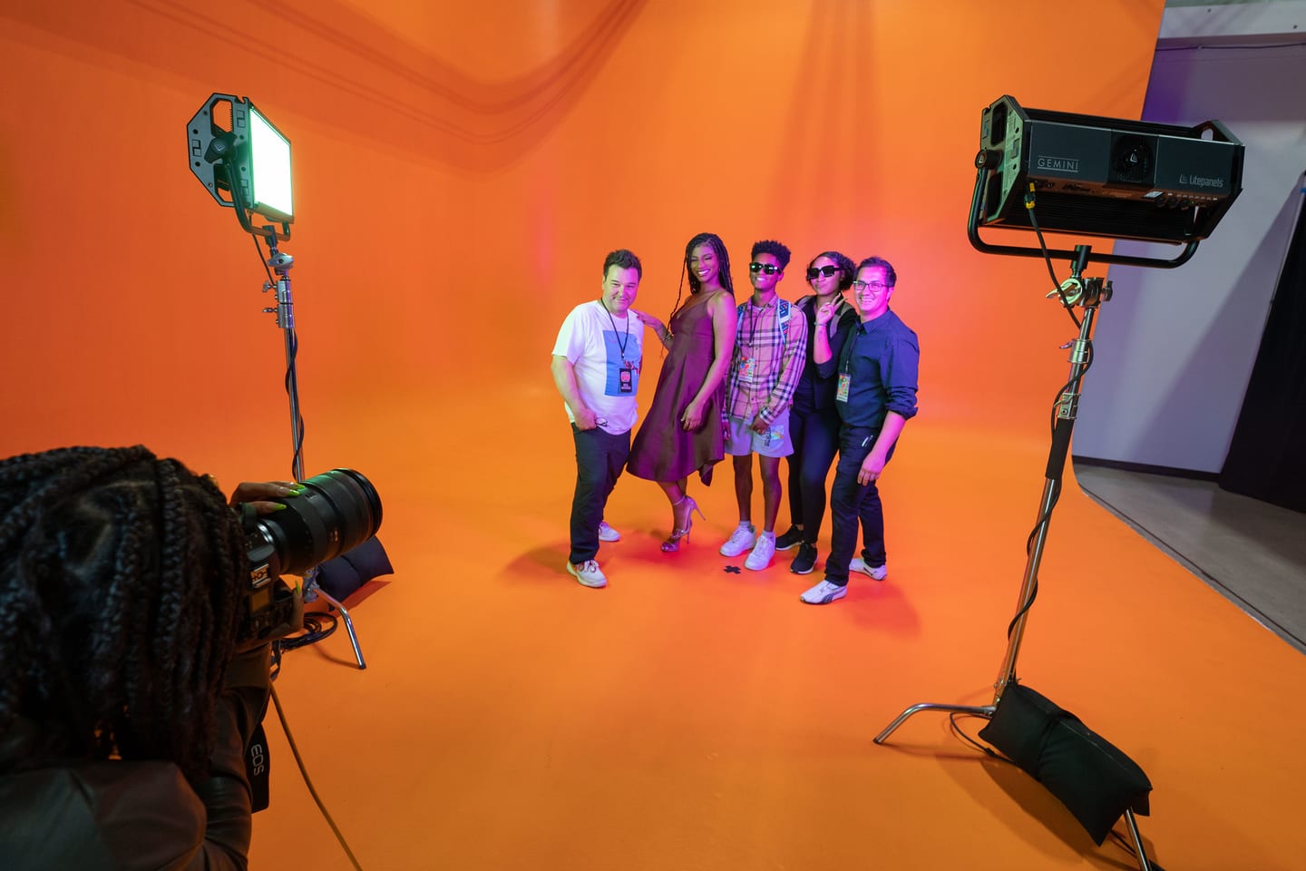 The honoree group being photographed and filmed, lighting and camera rigs visible