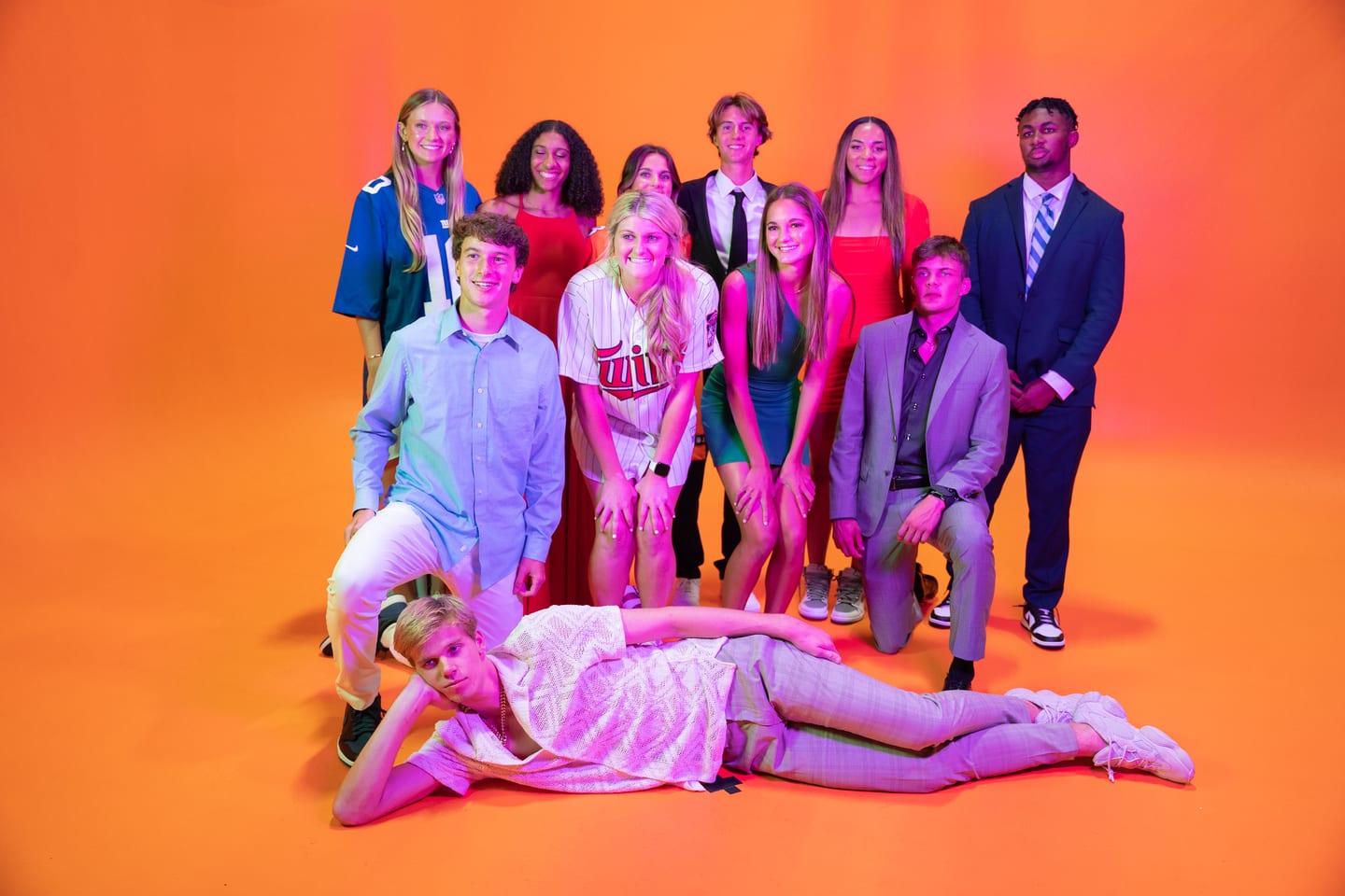 The Athlete of the Year honorees in a loose group pose on the orange backdrop