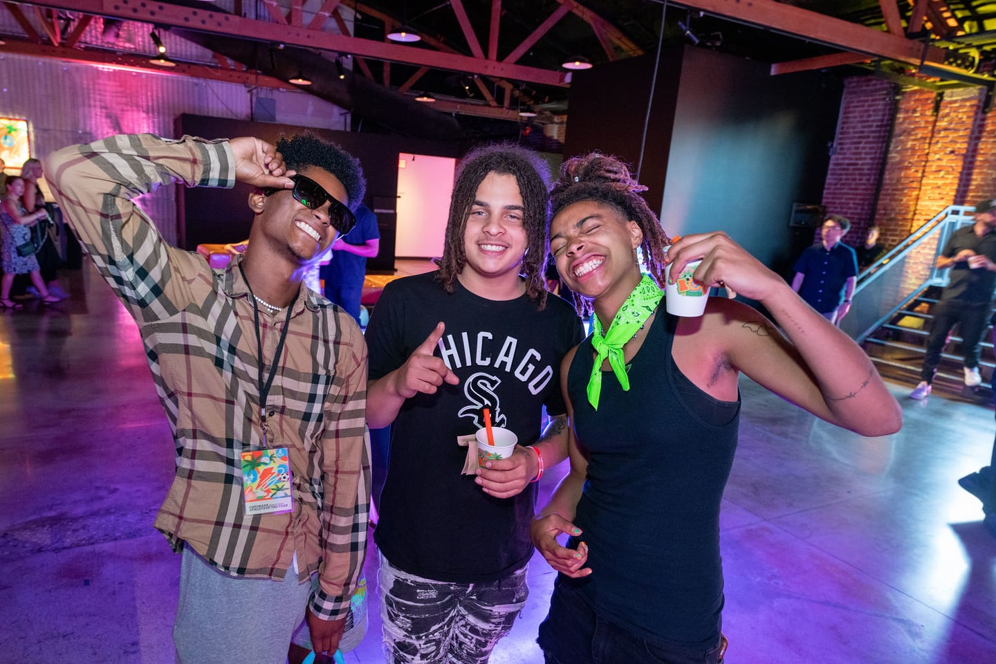 Three guests raising drinks together at the after-party