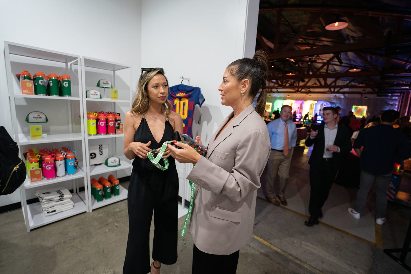 Guests talking beside a shelf of Gatorade bottles at the reception