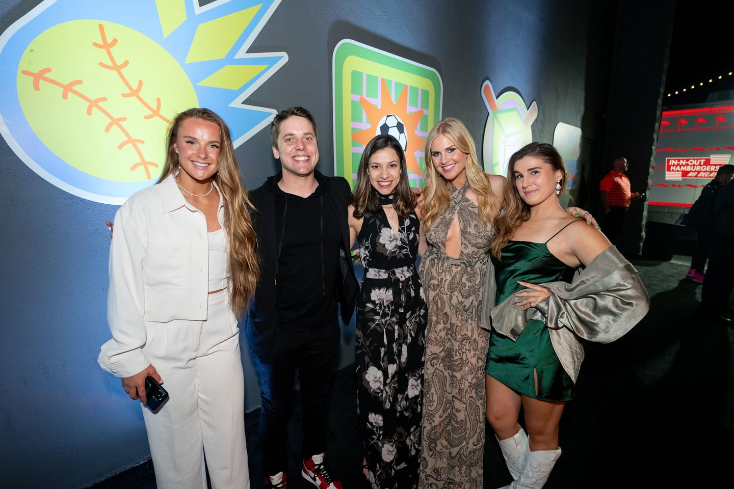 Five honorees photographed together in front of a softball backdrop