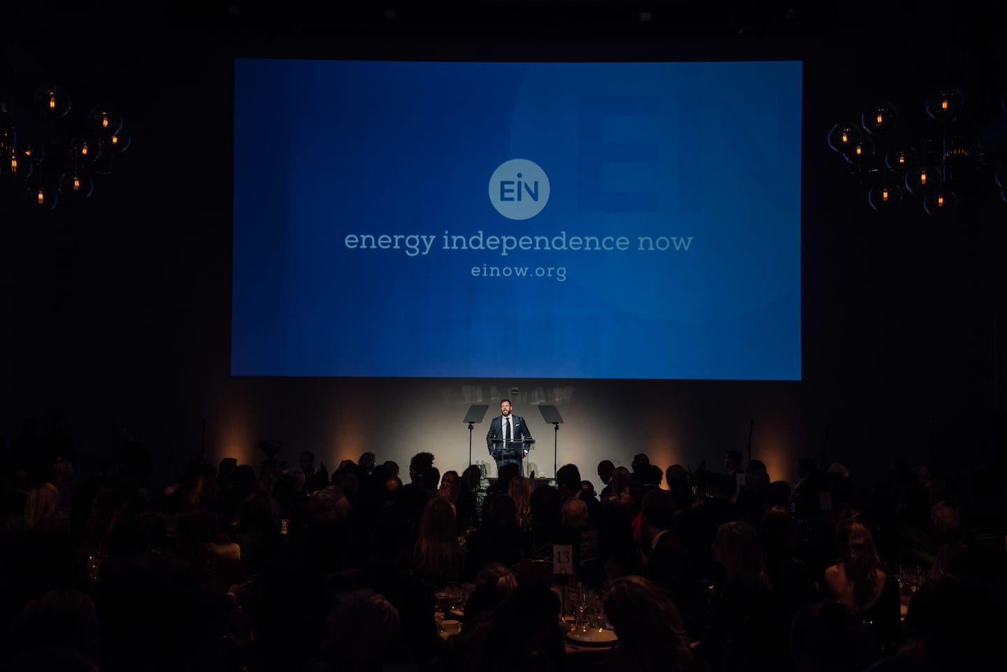 The gala room during a presentation, an Energy Independence Now screen behind the stage, at the 15th annual Global Green pre-Oscar gala at NeueHouse Hollywood