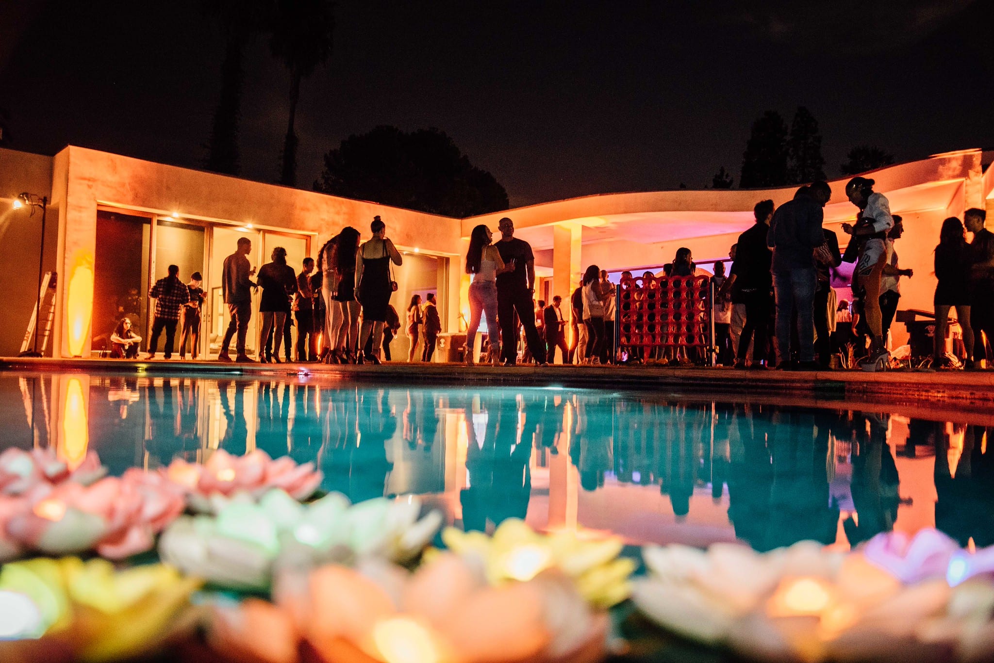 Estate pool with floating lotus lanterns at a private party in the Hollywood Hills at night