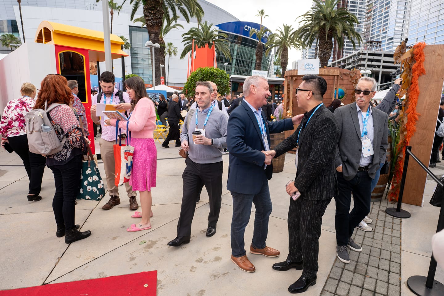 Delegates in suits talking outdoors between activations at IPW’s California Plaza