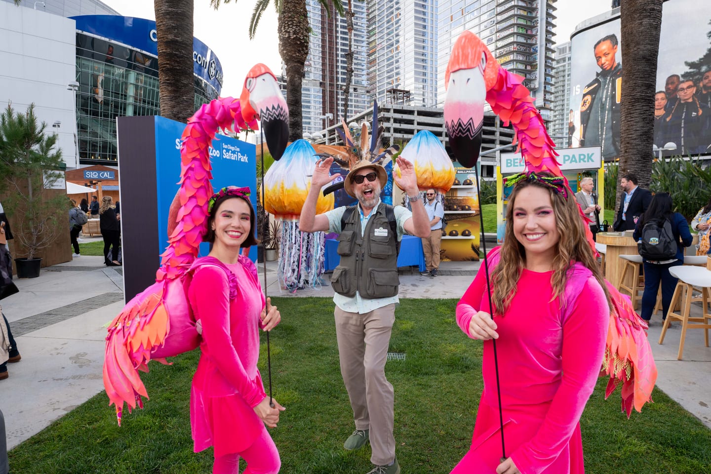 Costumed performers in pink with flamingo puppets entertaining guests outdoors at IPW’s California Plaza