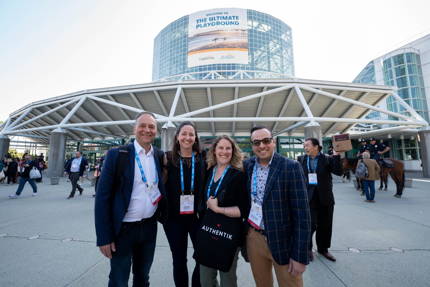 Four IPW delegates posing outside the Los Angeles Convention Center beneath a California the Ultimate Playground dome
