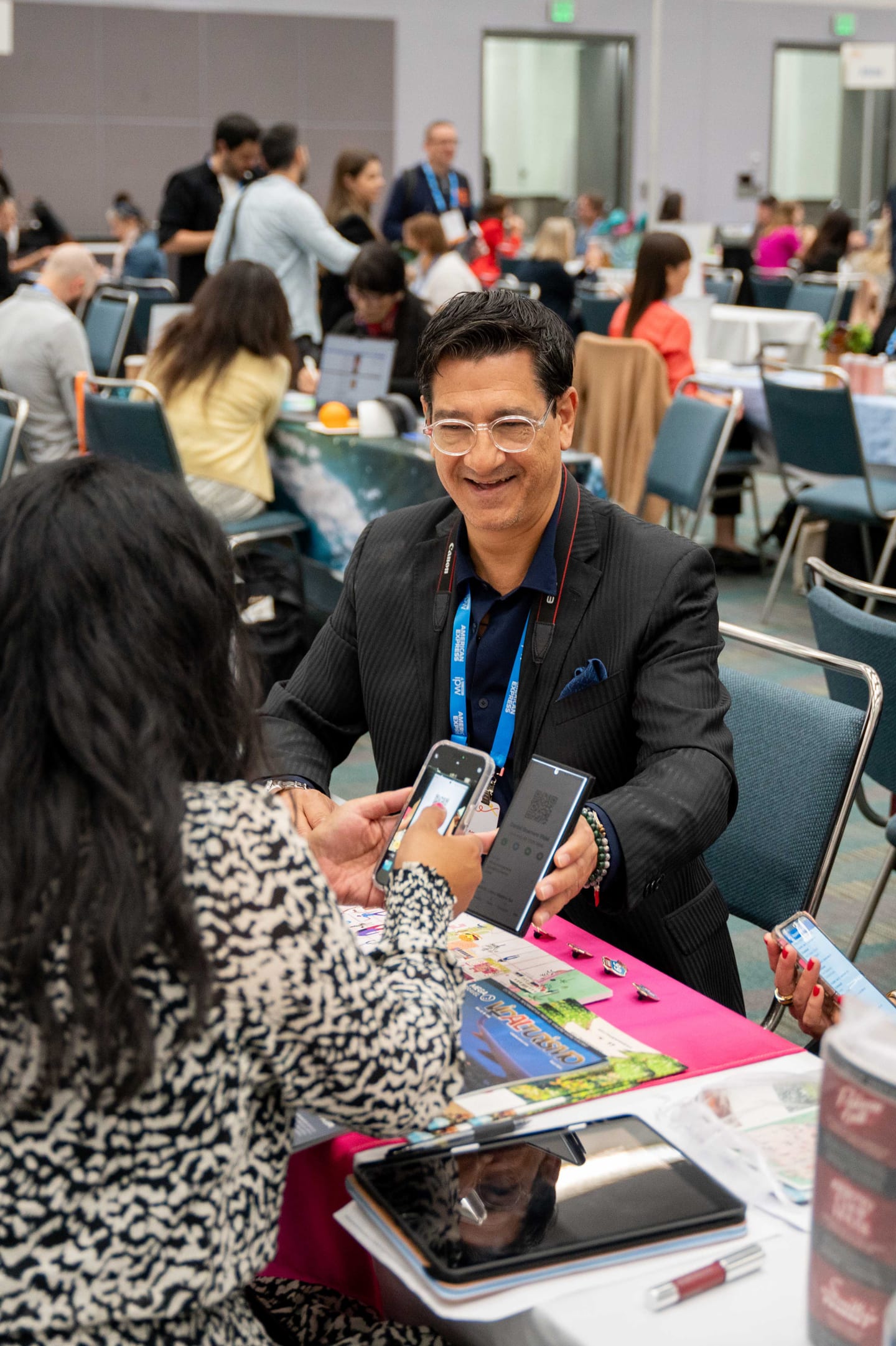 A delegate handing over materials across a table during a Media Marketplace appointment at IPW