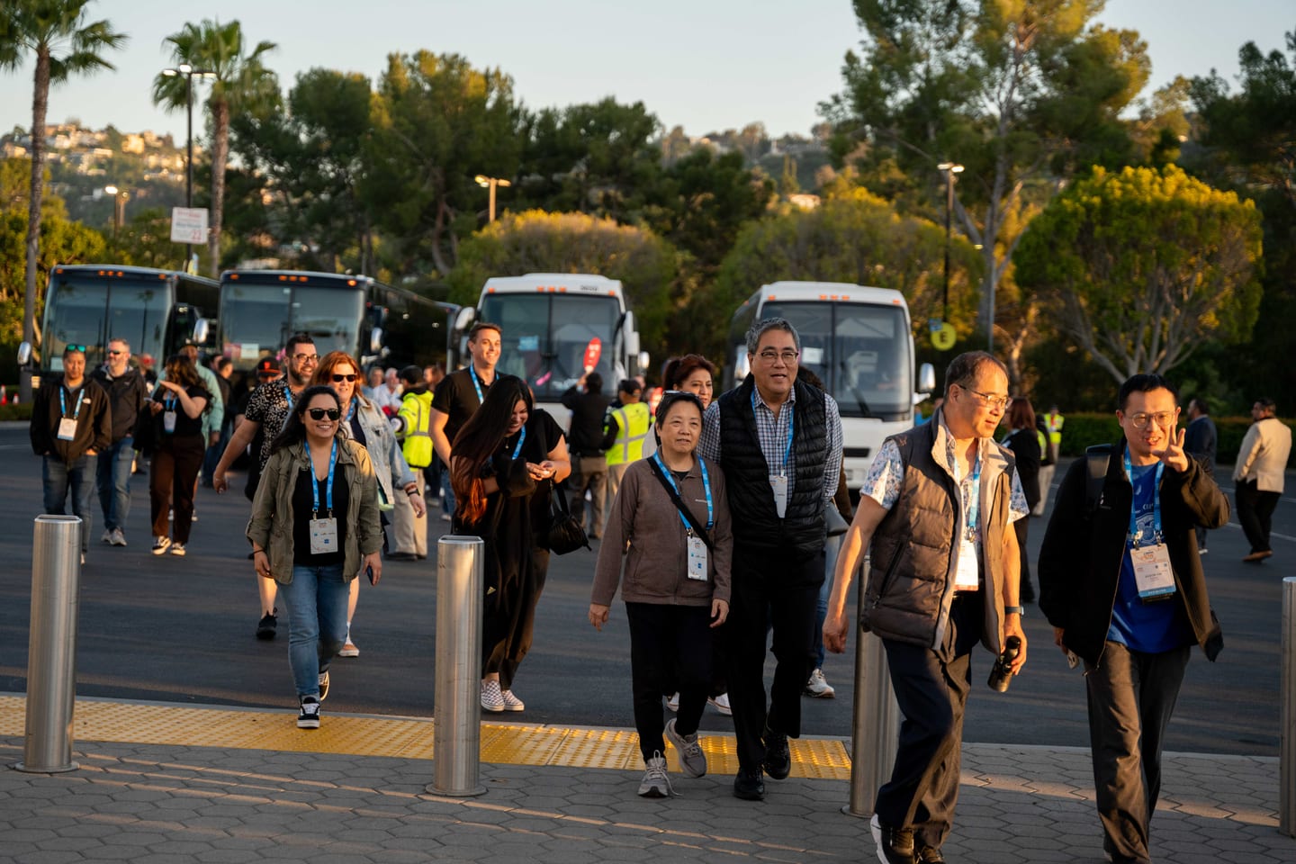 IPW delegates walking toward a line of motorcoaches waiting to take them to an offsite event