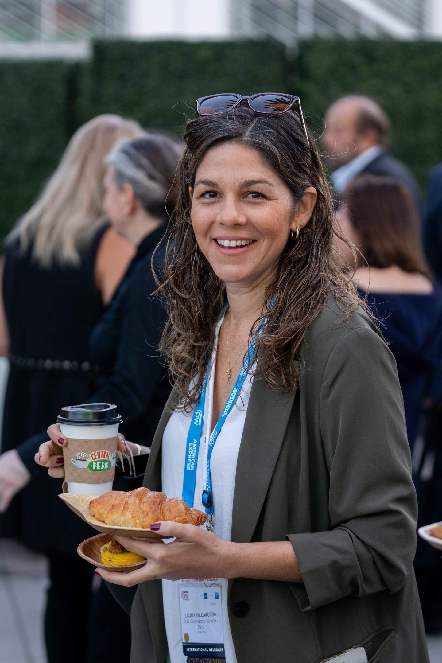 A delegate holding a coffee and a plate of pastries at an IPW morning networking break