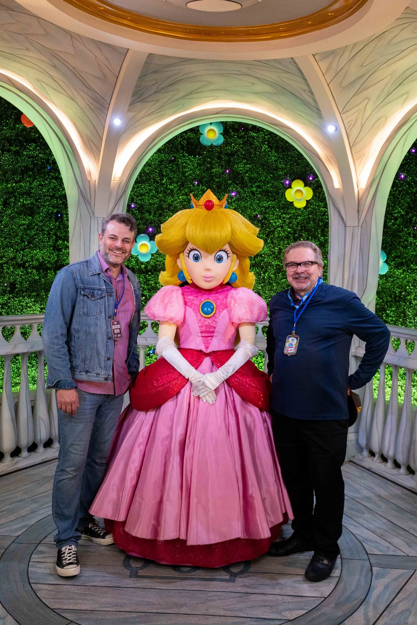Two IPW delegates posing with a costumed Princess Peach in a white gazebo in Super Nintendo World at Universal Studios Hollywood