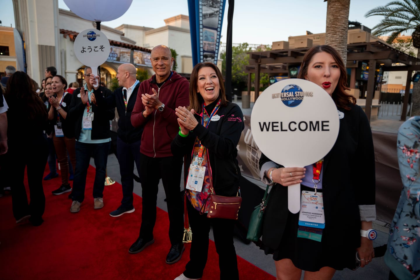 Universal Studios staff holding welcome paddles and applauding IPW delegates arriving on a red carpet