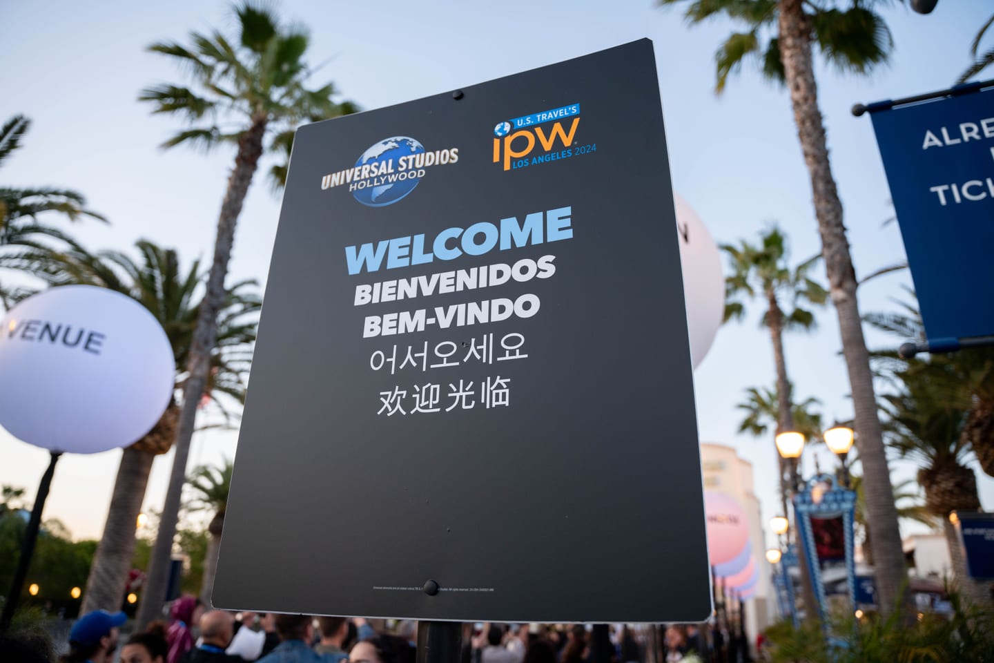 A co-branded Universal Studios Hollywood and IPW welcome sign printed in English, Spanish, Portuguese, Korean and Chinese