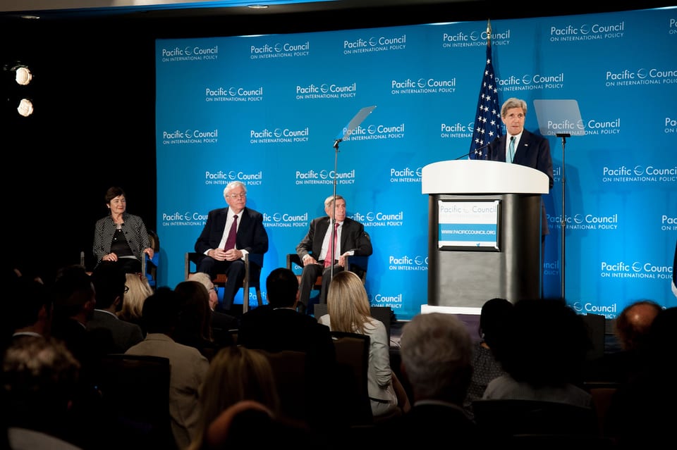 Former Secretary of State John Kerry speaking at a podium at the Pacific Council on International Policy