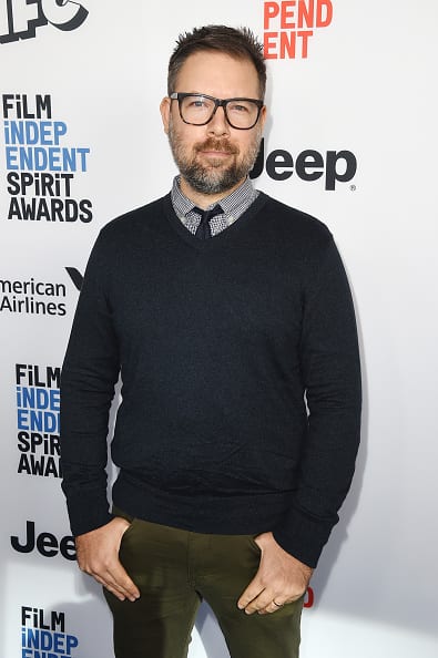 Kyle Espeleta at the Film Independent Spirit Awards Nominee Brunch, standing in front of the Spirit Awards step-and-repeat