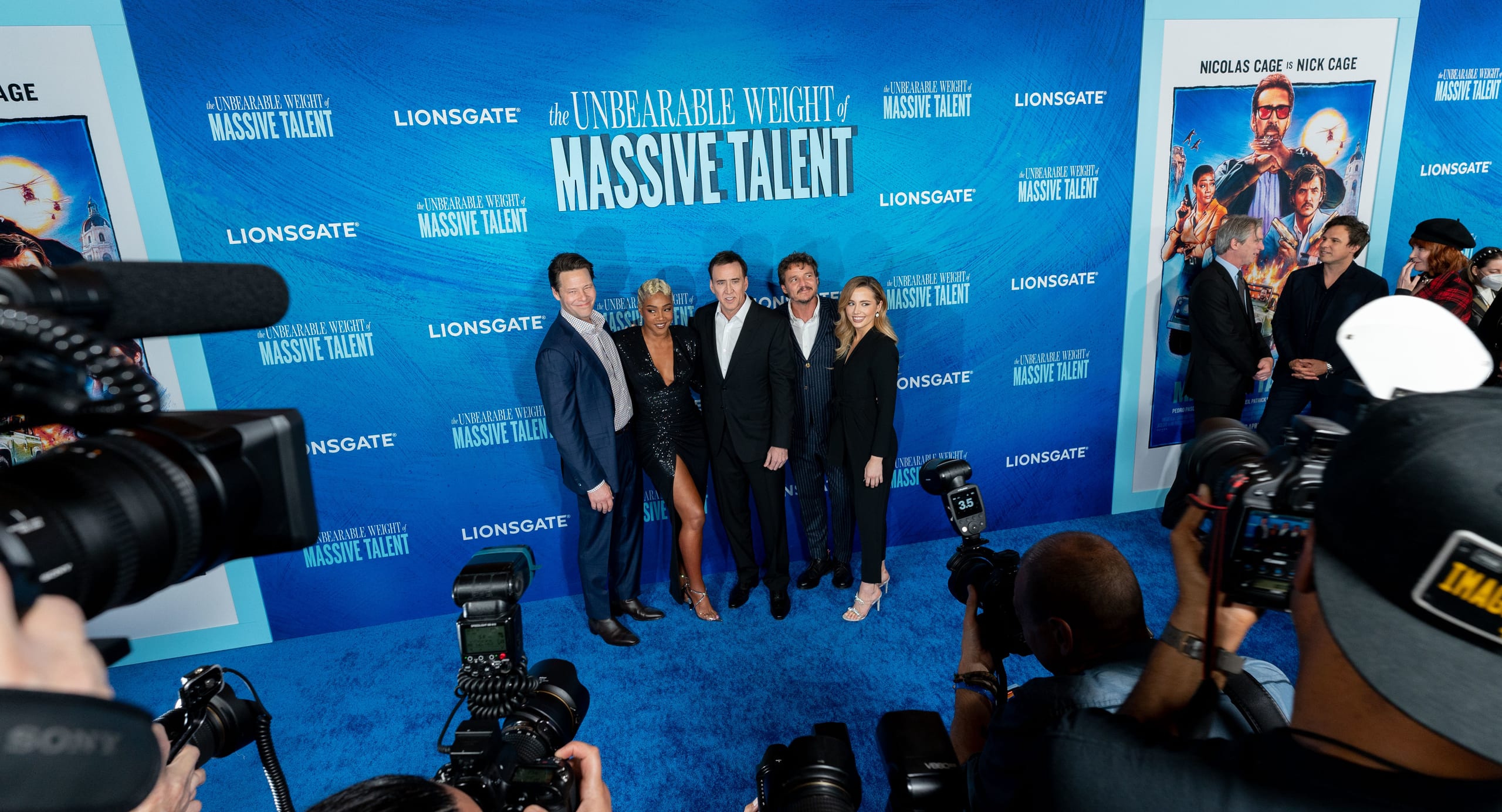 Ike Barinholtz, Tiffany Haddish, Nicolas Cage, Pedro Pascal and Lily Mo Sheen posed together on the blue carpet in front of a Lionsgate step-and-repeat reading The Unbearable Weight of Massive Talent, the press pit’s cameras and flashes filling the foreground