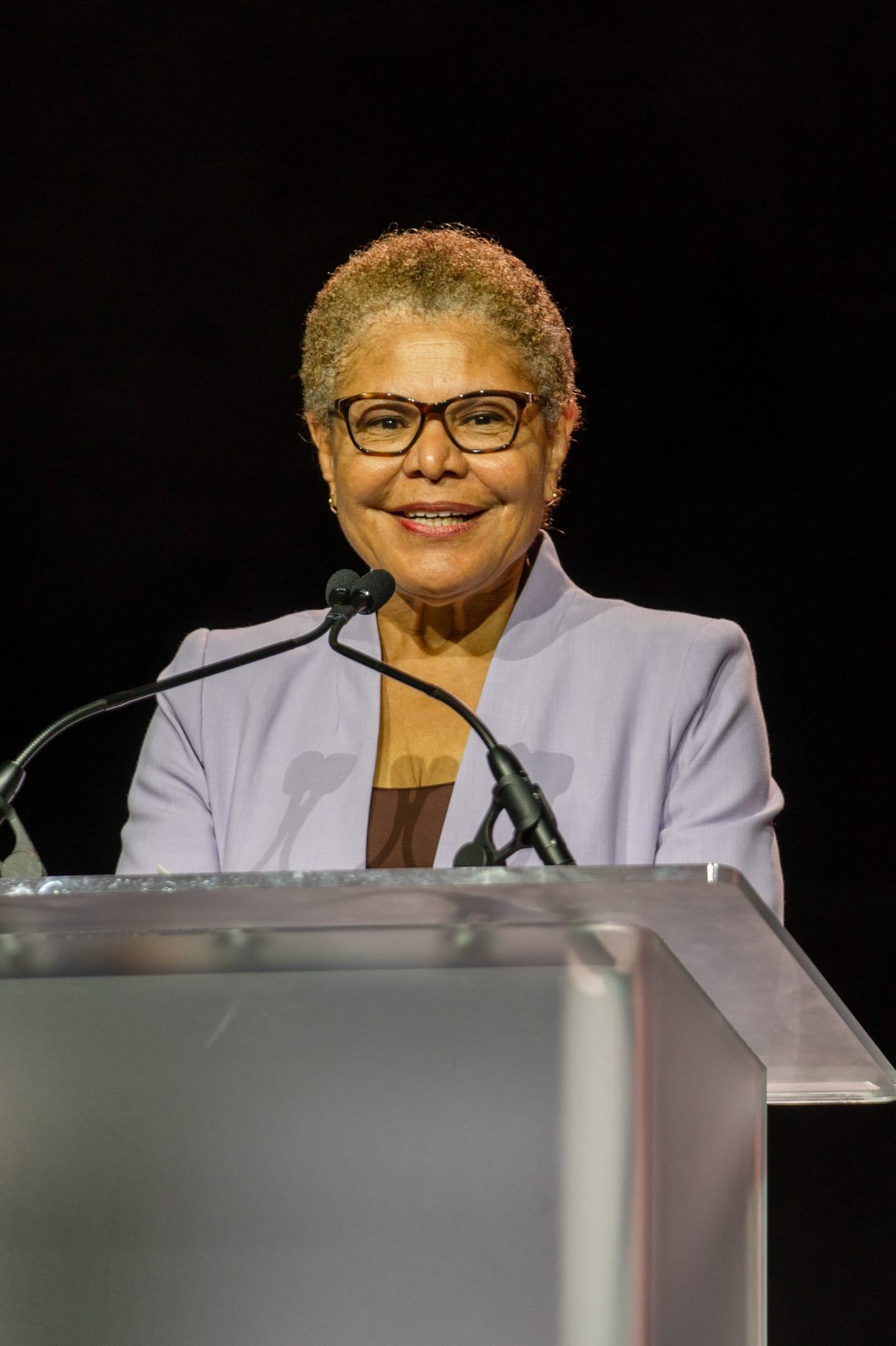 Los Angeles Mayor Karen Bass smiling at a lit acrylic podium during her welcome to IPW