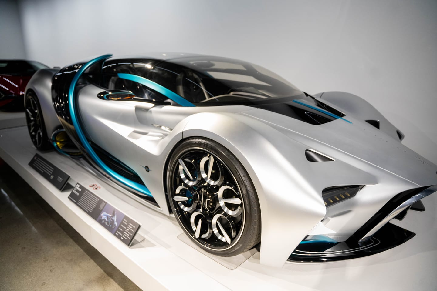 The silver and teal 2022 Hyperion XP-1 hydrogen hypercar prototype on a white display plinth at the Petersen Automotive Museum