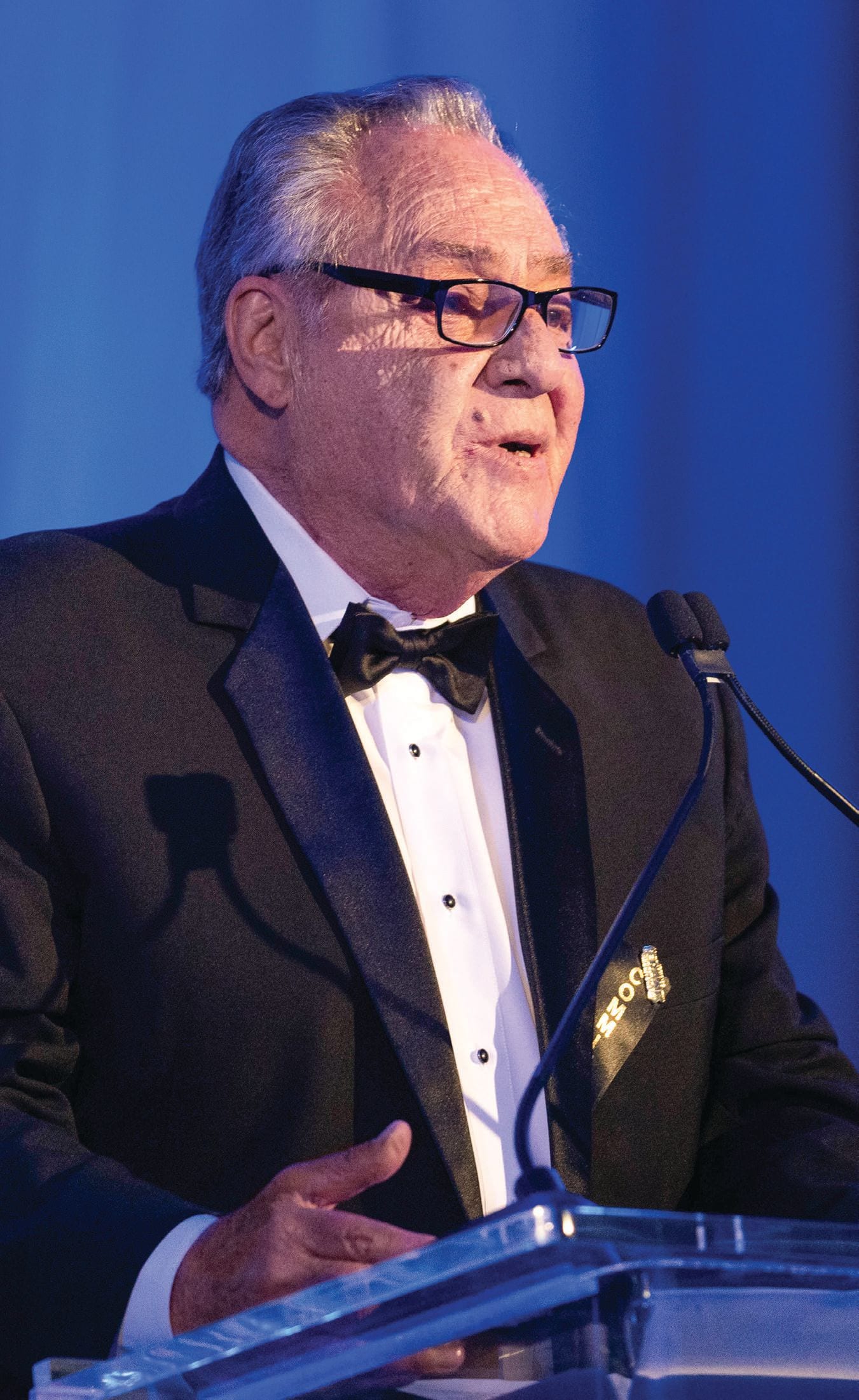 Honoree at a black-tie podium, photographed for Modern Luxury