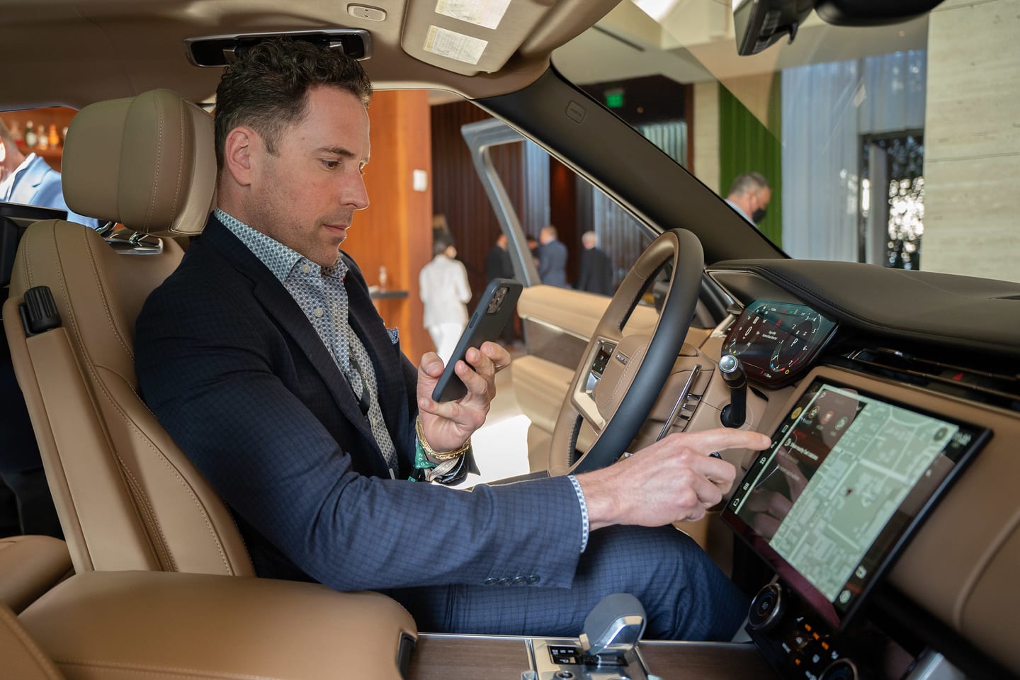 A guest in the driver’s seat exploring the Range Rover infotainment display at a brand launch
