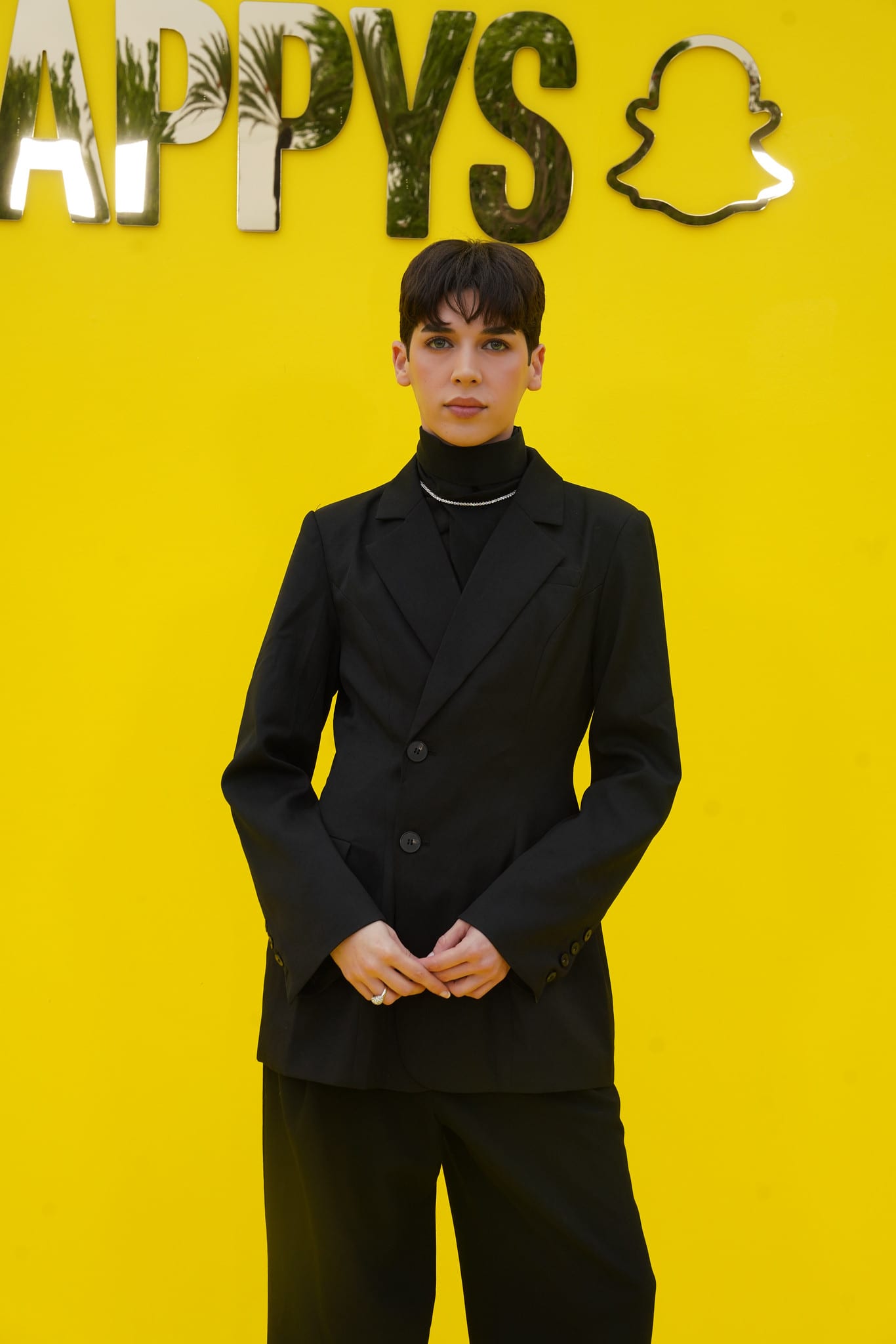 A guest in an all-black suit against the yellow SNAPPYS backdrop