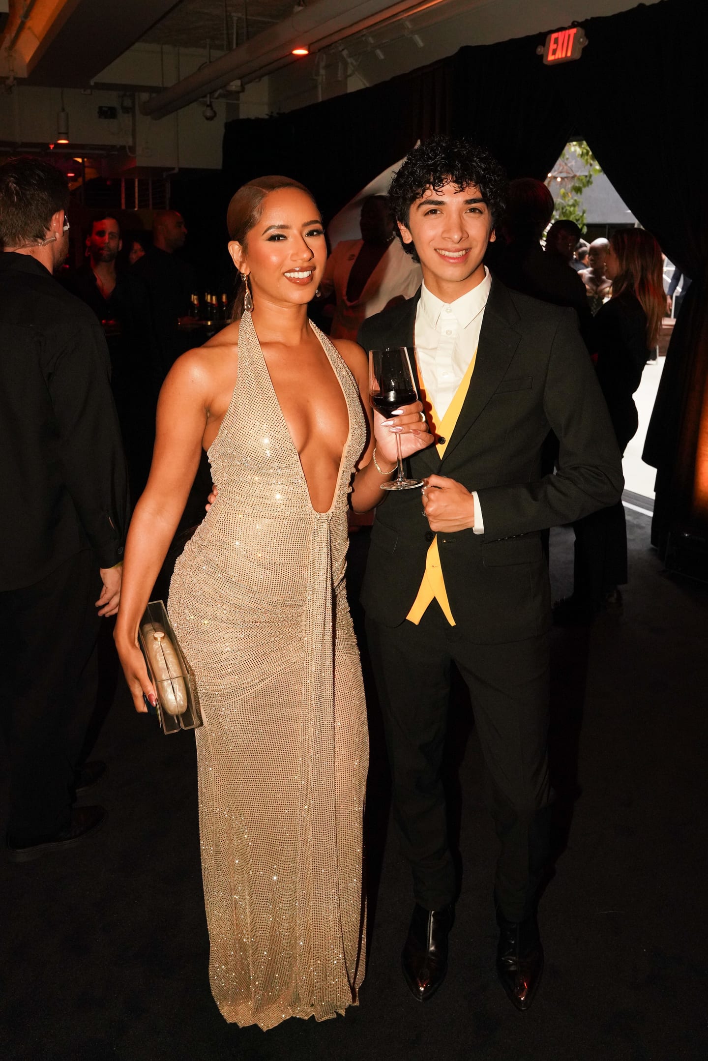 A couple photographed together, one in a gold gown, at the entrance