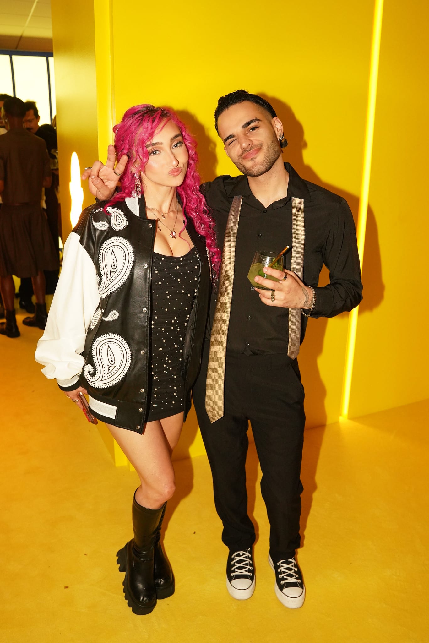 Two guests posing together against the yellow backdrop