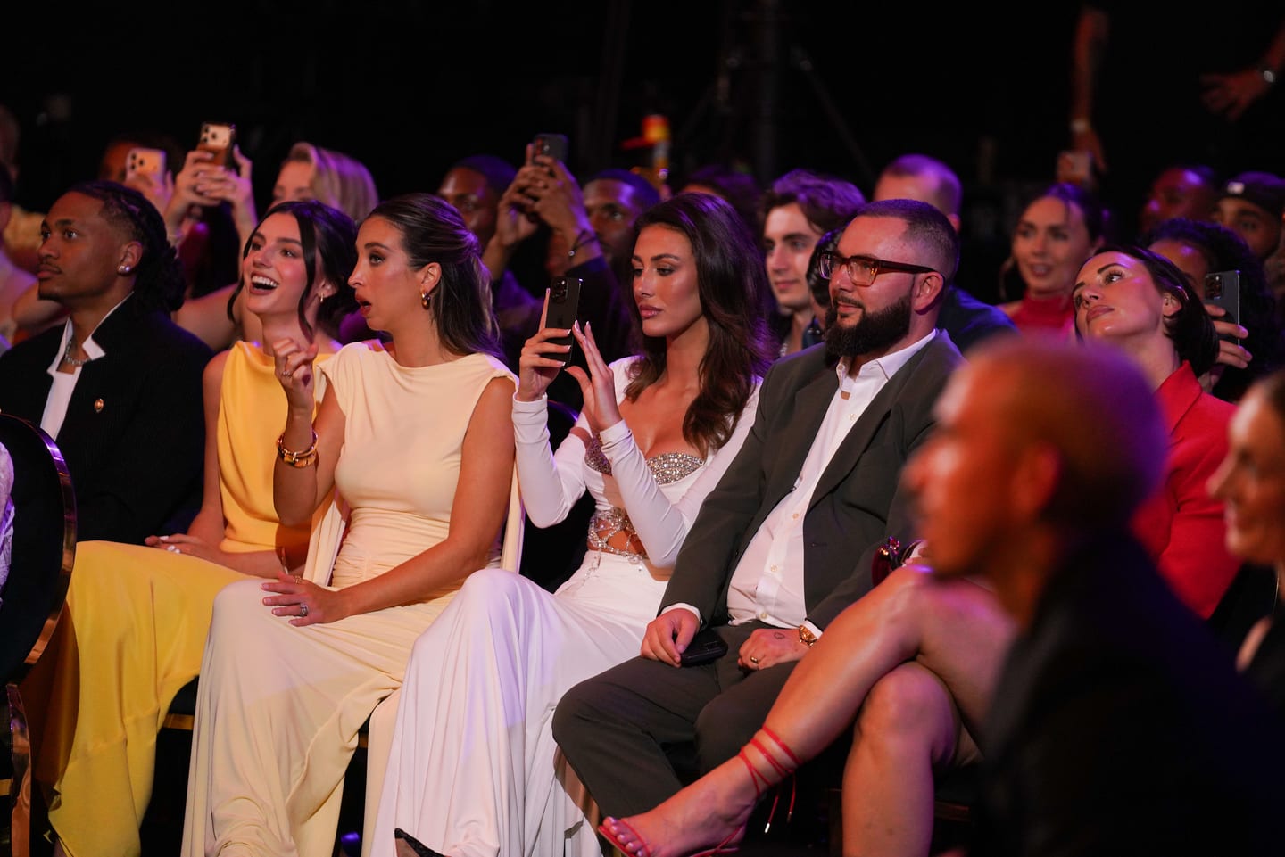 The front row of guests filming the stage on their phones