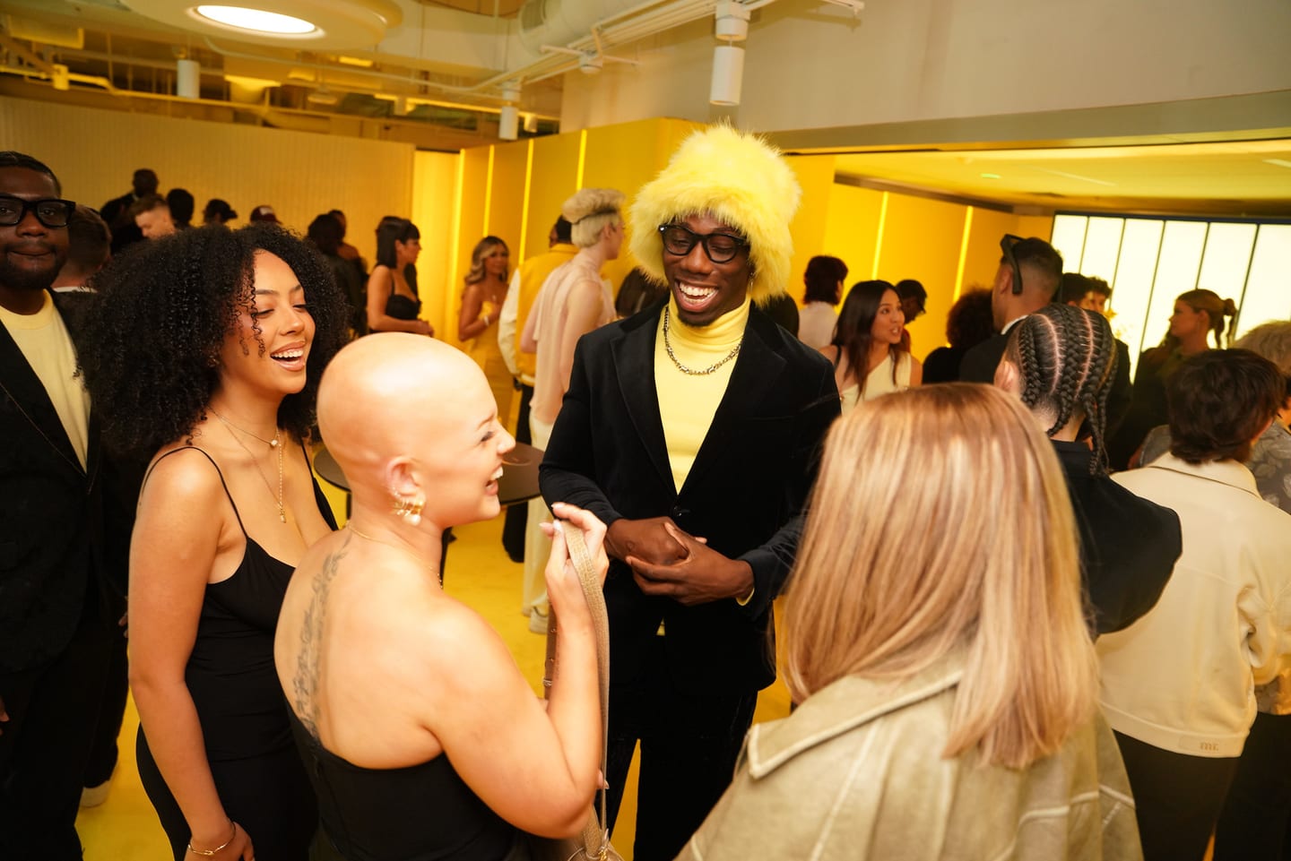 Guests mingling in a yellow-lit room