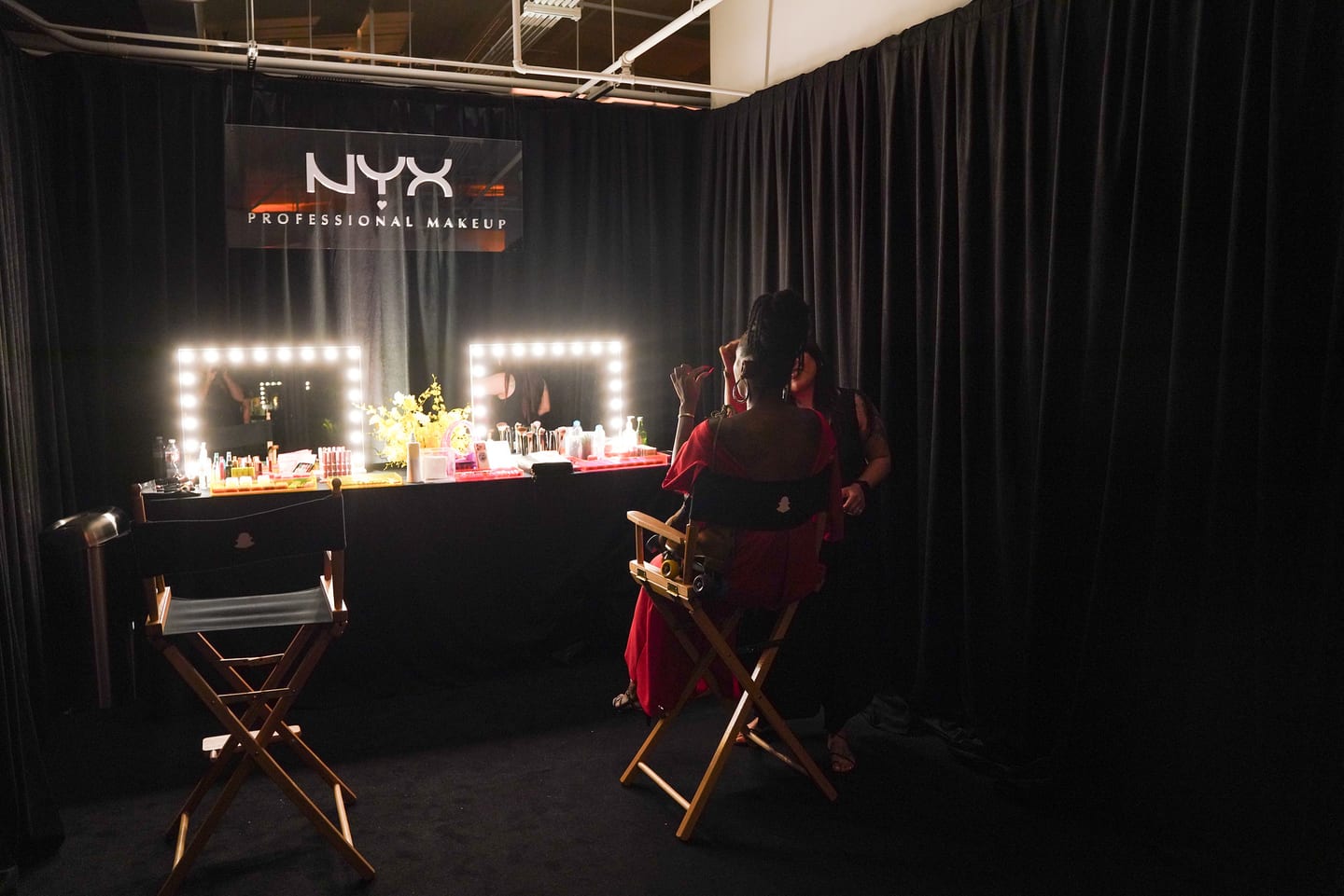 The NYX Professional Makeup beauty bar with lit mirrors and director chairs