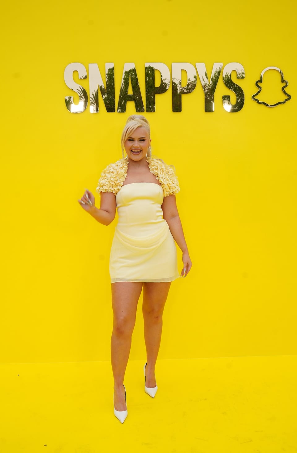 Influencer Ashlee Keating in a yellow dress on the yellow carpet against the SNAPPYS backdrop at Snapchat’s creator awards in Santa Monica
