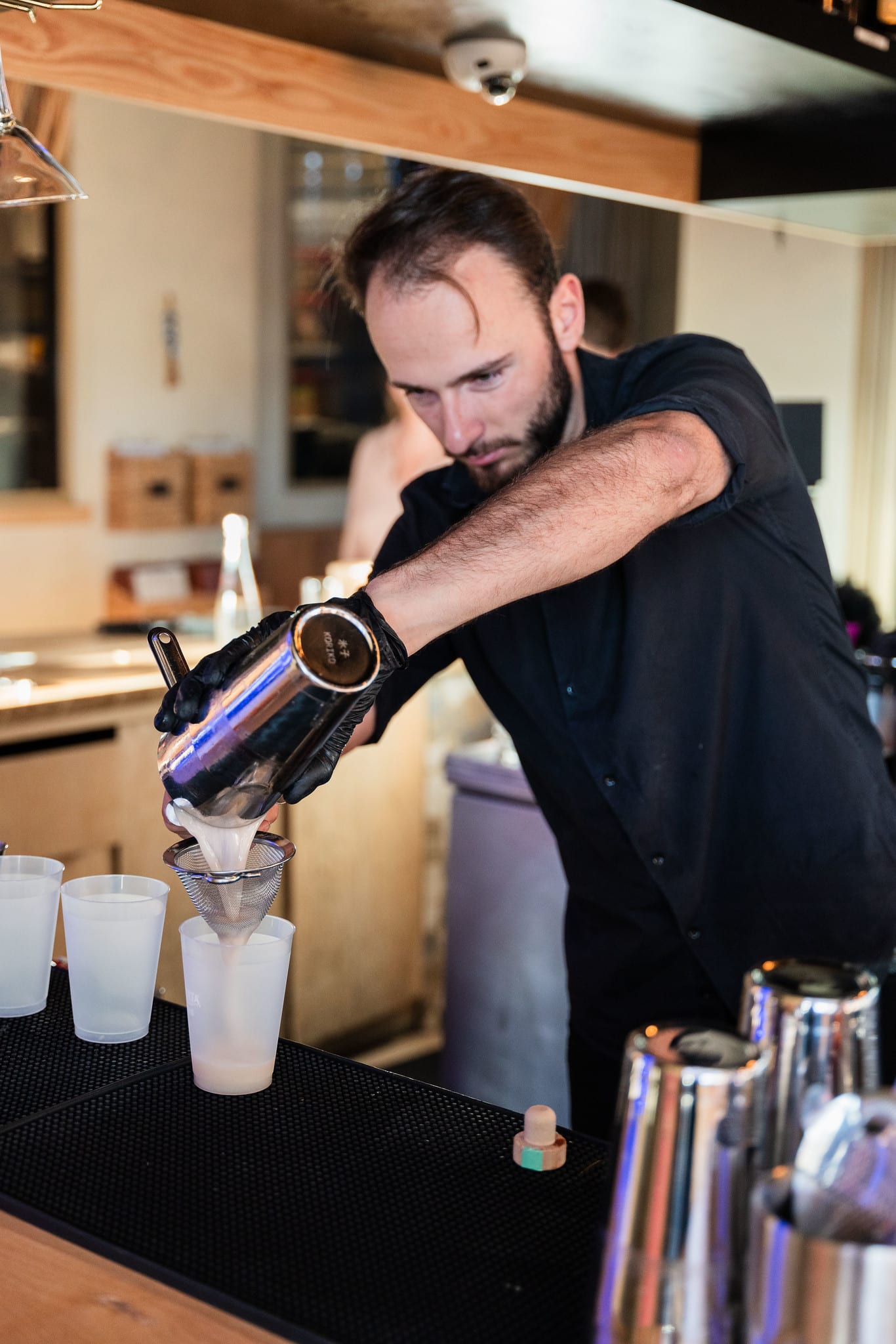 A bartender pouring a cocktail from a shaker behind the rooftop bar at the TikTok and Ulta Beauty #TikTokBeauty dinner on the LouLou rooftop in Santa Monica