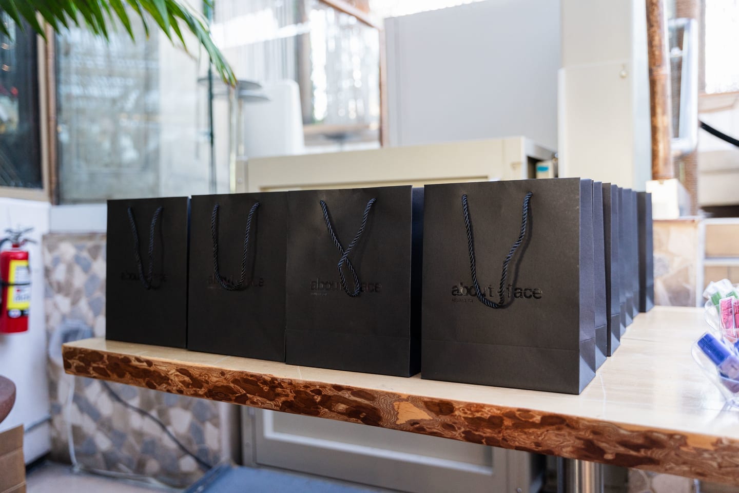 Black gift bags lined along a live-edge wooden counter at the TikTok and Ulta Beauty #TikTokBeauty dinner on the LouLou rooftop in Santa Monica