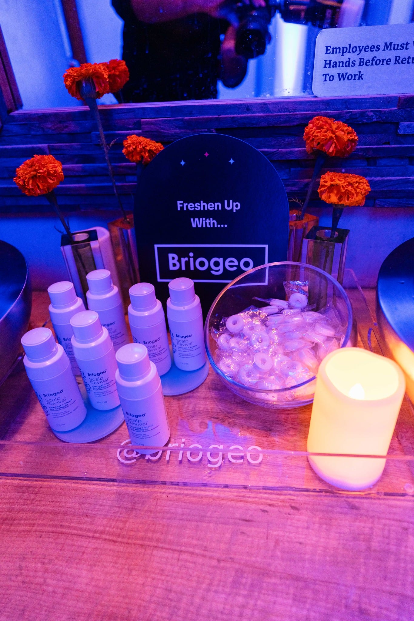 Briogeo haircare bottles arranged on ice under blue light at a brand sampling station at the TikTok and Ulta Beauty #TikTokBeauty dinner on the LouLou rooftop in Santa Monica
