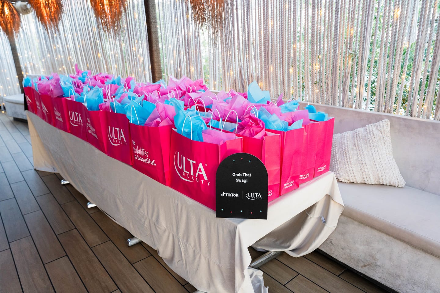 A wide view of the gifting table filled with pink Ulta Beauty bags on the rooftop at the TikTok and Ulta Beauty #TikTokBeauty dinner on the LouLou rooftop in Santa Monica