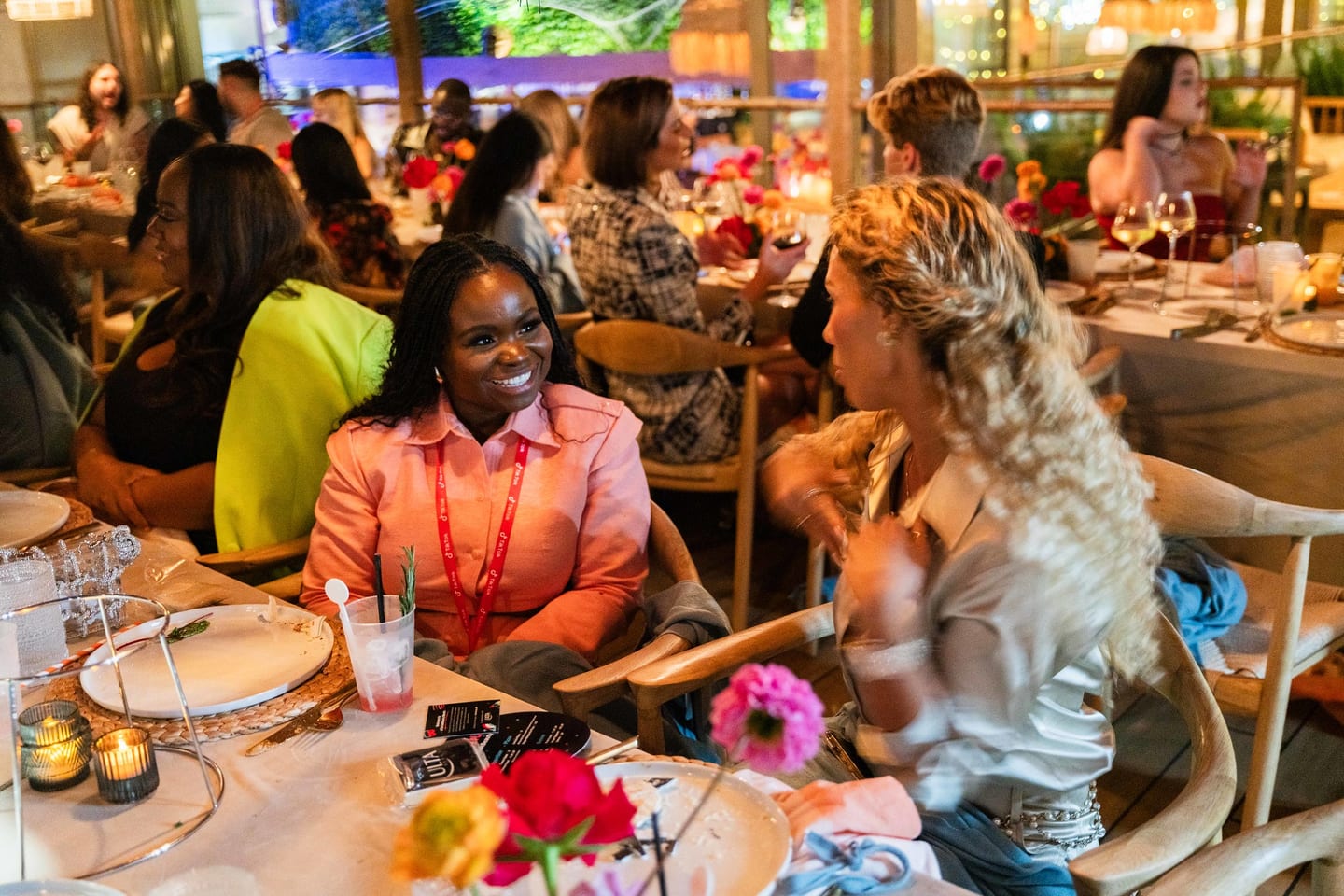 Three guests laughing together at the dinner table at the TikTok and Ulta Beauty #TikTokBeauty dinner on the LouLou rooftop in Santa Monica
